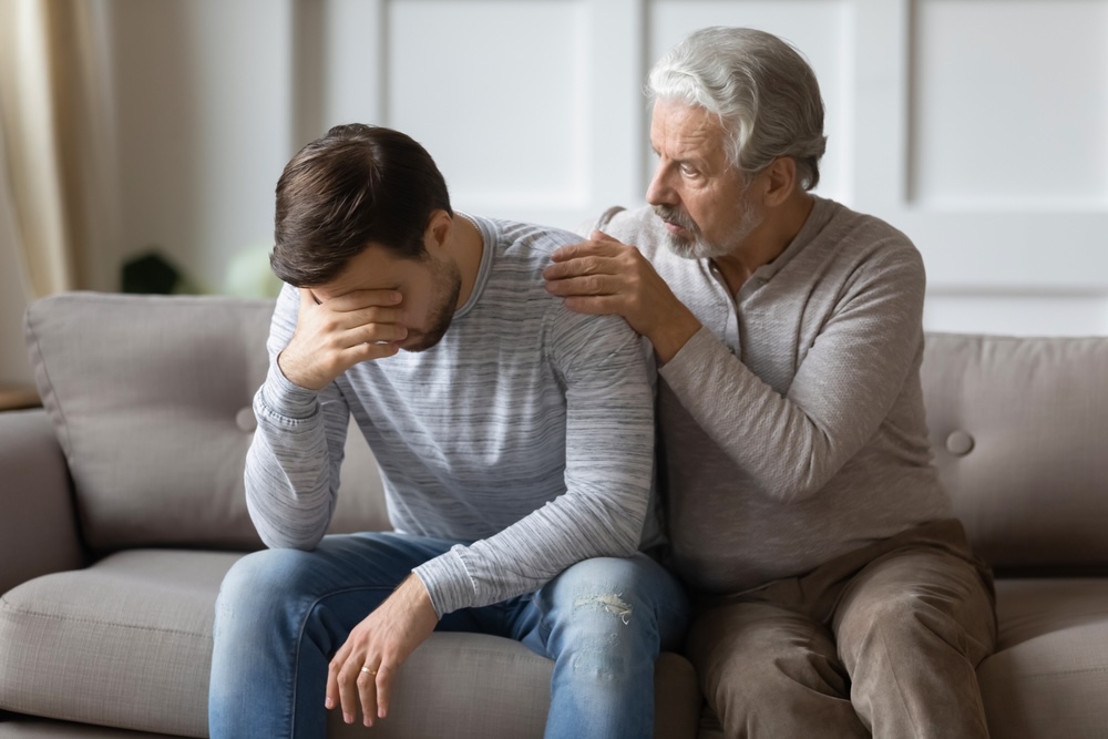 Father comforting his adult son struggling with mental heath