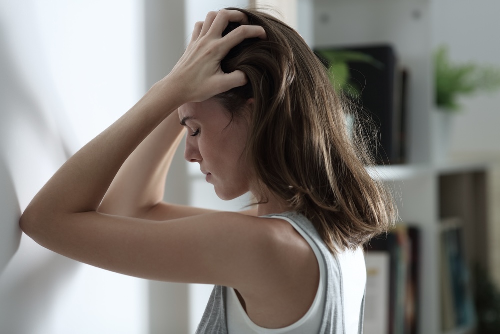 Female feeling anxious with her forehead on the wall