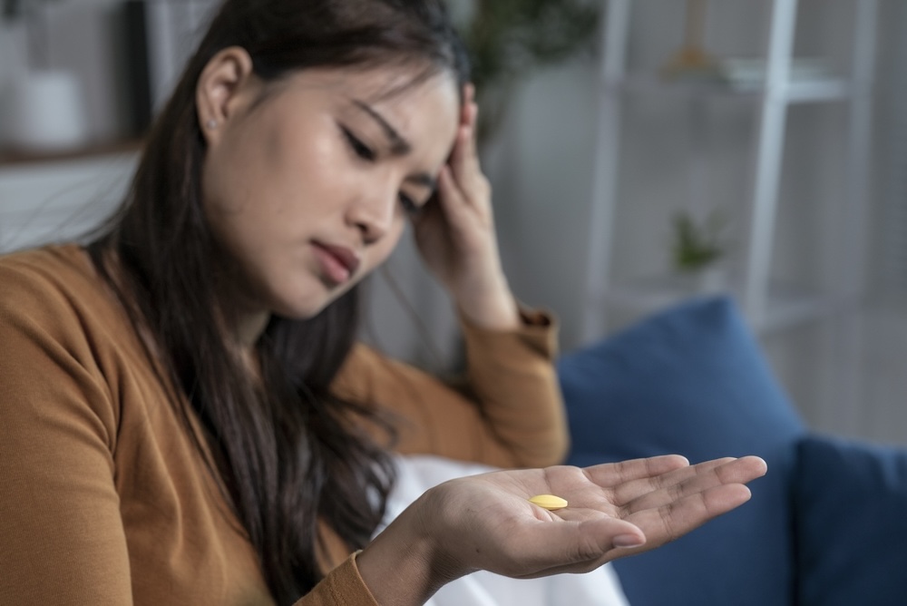 Female struggling with anxiety holding alprazolam pill