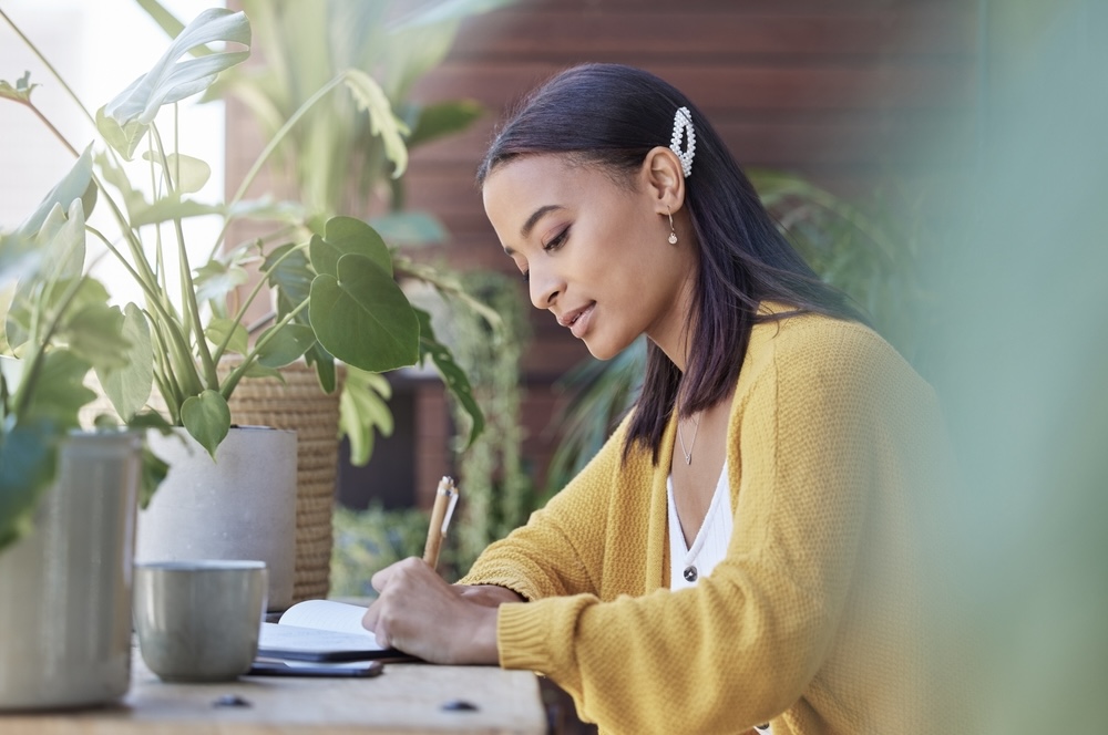 Female journaling her thoughts as form of mental health detox