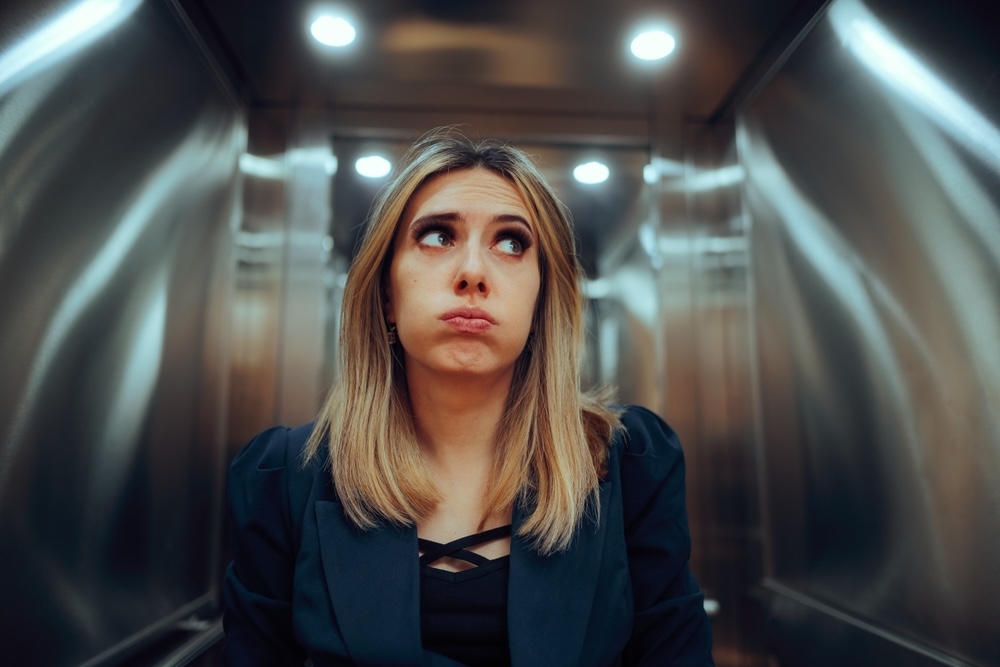 Woman in an elevator feeling anxious